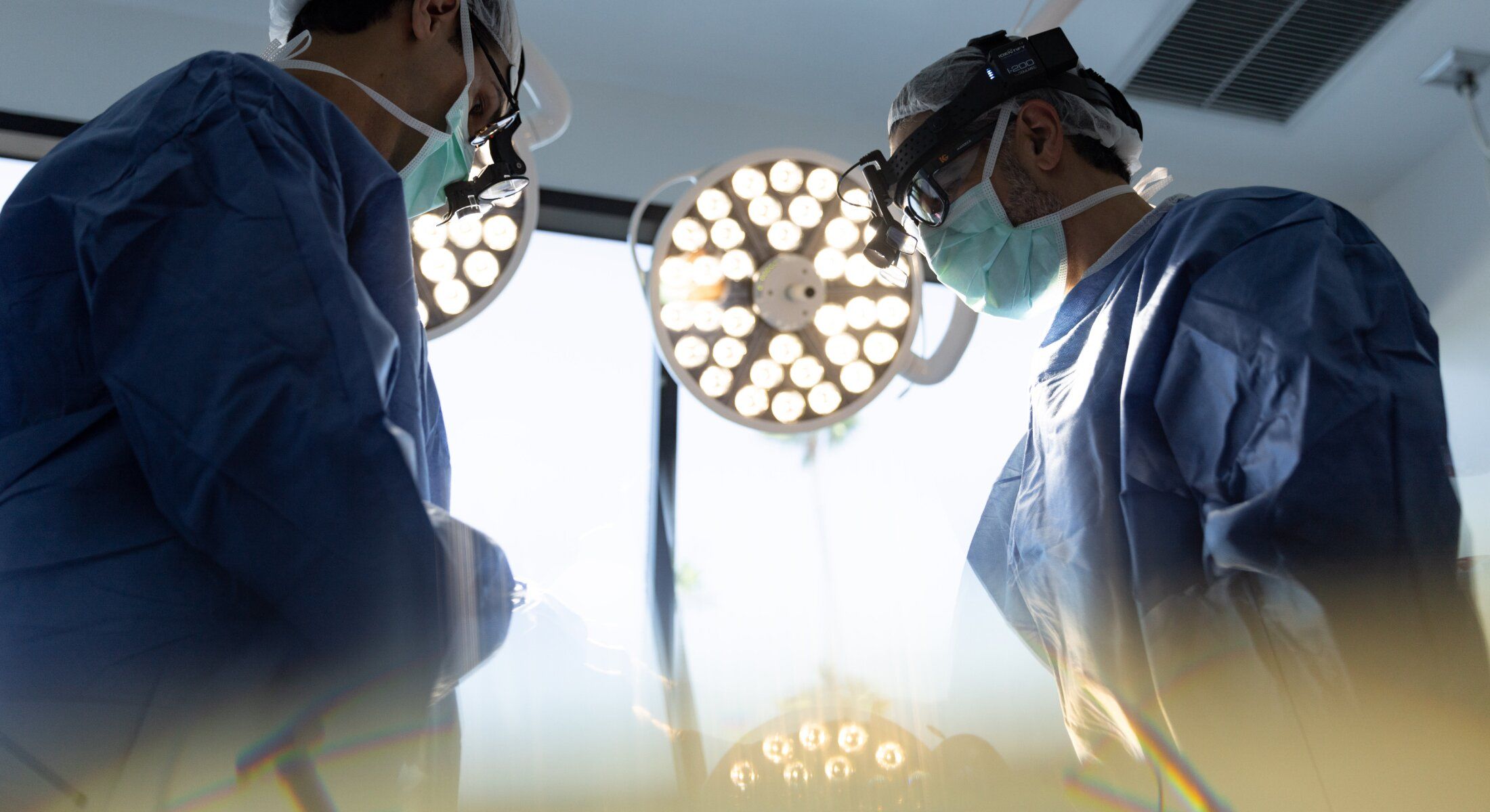 Surgeons working under bright operating room lights.