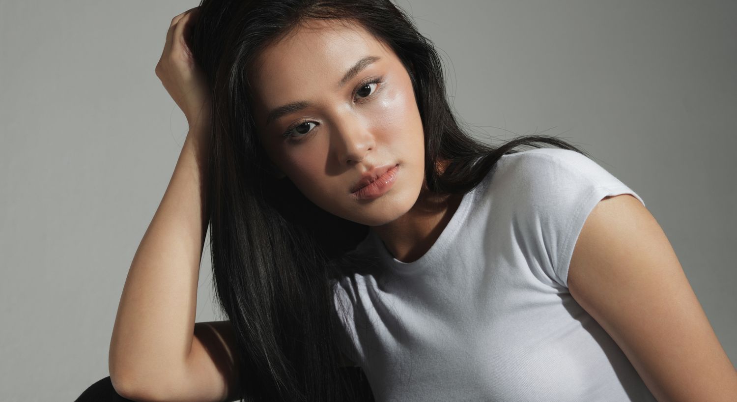 Young woman with long hair in white shirt.