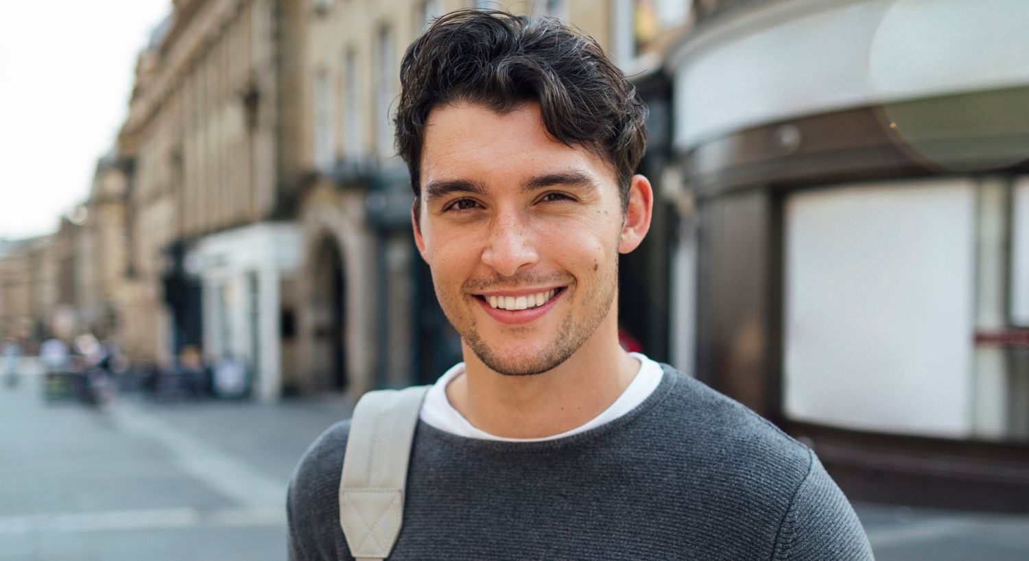 Smiling young man in urban setting.