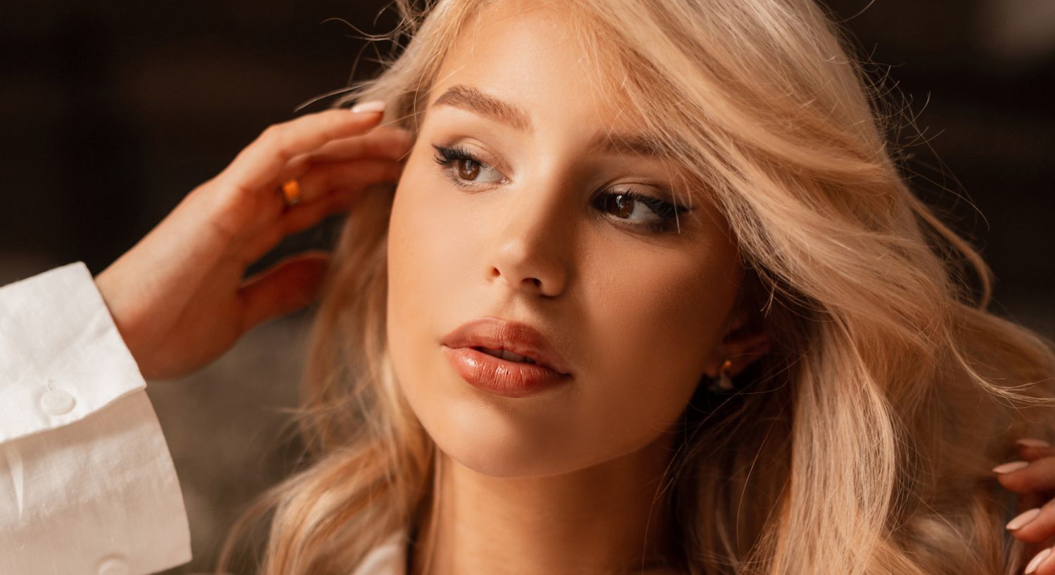 Woman styling her hair with soft lighting.