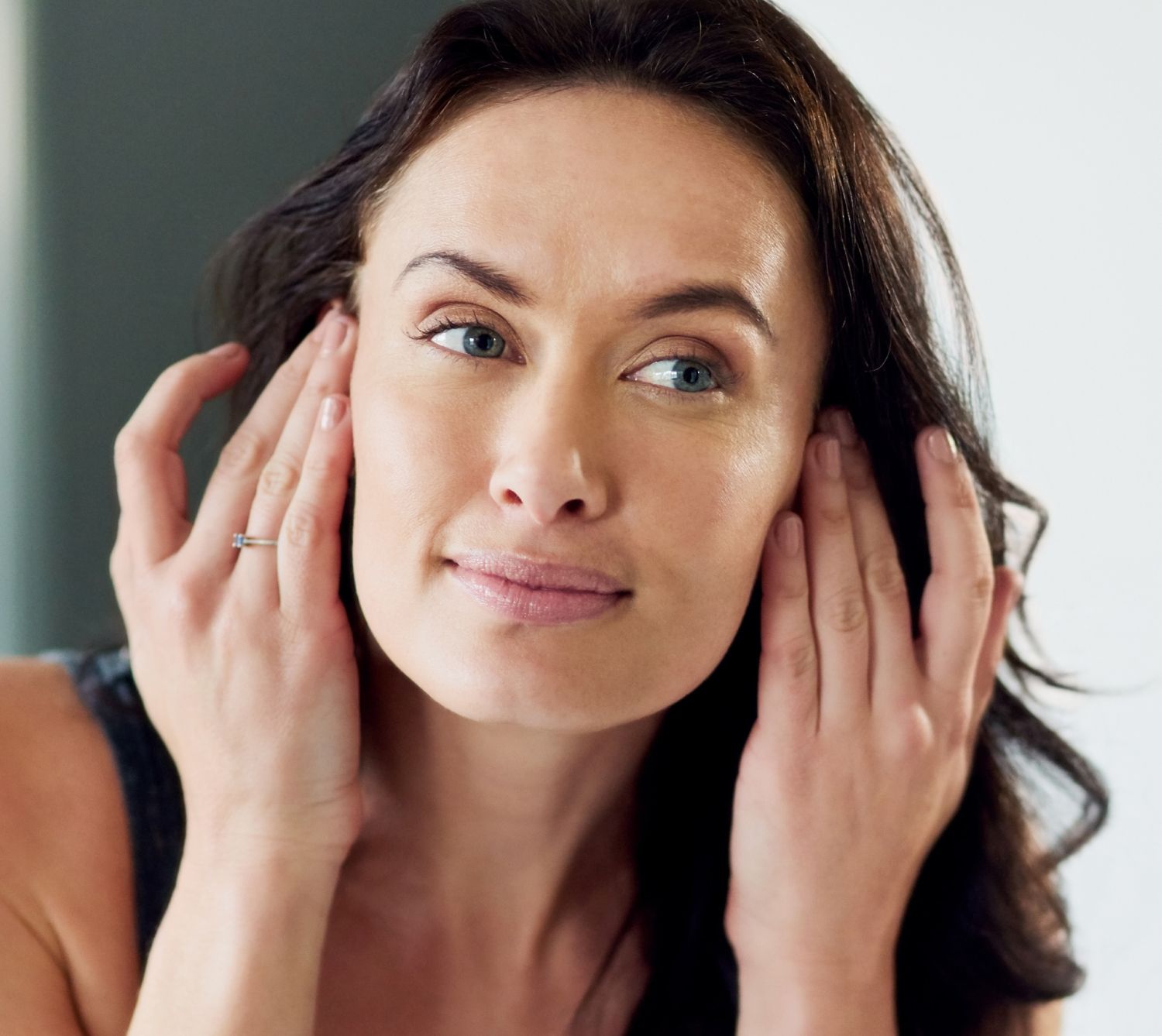 Woman touching her face in natural light.